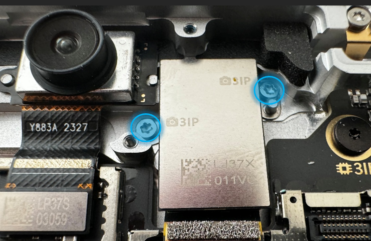 Screenshot that shows rear camera being lifted from enclosure after its two screws are removed.