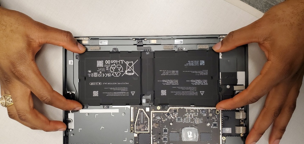 Hands holding a black rectangular object Description automatically generated